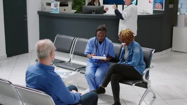 African American Nurse Doing Consultation Patient Waiting Area Lobby Taking — ストック動画