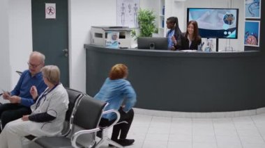 Young patient having appointment with medic at medical facility, filling in report papers to attend checkup visit examination. Receptionist helping woman sitting in waiting room.