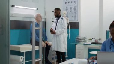Medic specialist holding bottle of pills to cure old patient with sickness, giving prescription medicine and antibiotics treatment to elderly man. Doctor doing checkup consultation.