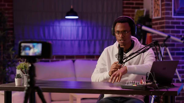 Afro-amerikan içerik yaratıcısı video kamera kullanarak video bloğu kaydediyor ve ana stüdyodaki şovunu izlediğiniz için teşekkür ediyor. Ünlü etkili internet eğlence podcast 'i canlı yayında.