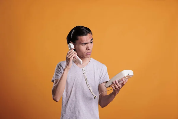 Молодой Смущенный Человек Разговаривает Стационарному Телефону Загадочный Азиатский Подросток Болтает — стоковое фото