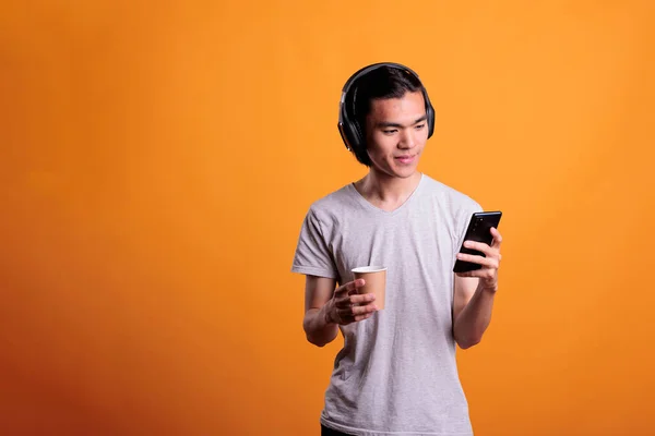 Man Wireless Headphones Listening Podcast Mobile Phone Holding Coffee Smiling —  Fotos de Stock