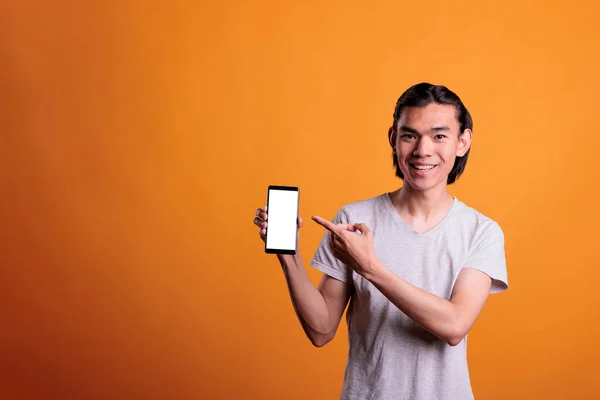 Young Asian Man Pointing Smartphone Blank Screen Copy Space Teenager — Zdjęcie stockowe