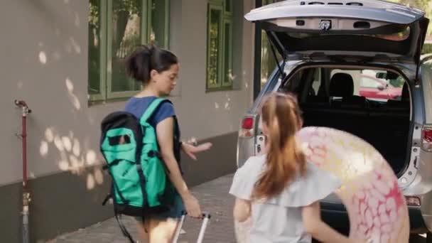 Mother Daughter Putting Luggage Car Trunk While Enjoying Holiday Field — Video