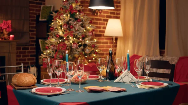 Empty interior of festive traditional Christmas dinner table with authentic decorative cutlery. Cozy and ornate looking living room with seasonal and positive style while nobody in it.