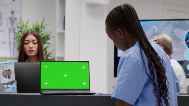 Африканская Американская Медсестра Использует Ноутбук Зеленым Экраном Стойке Регистрации Больницы — стоковое видео