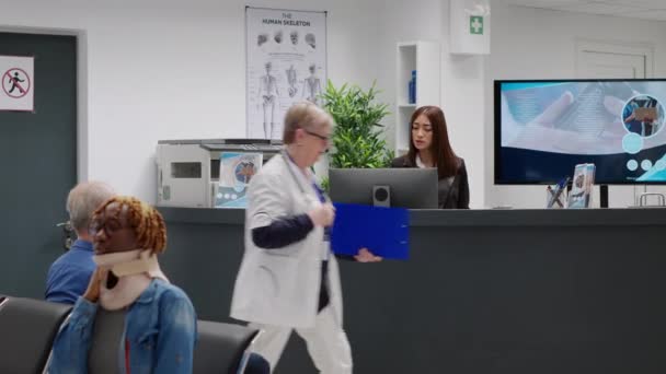 Diverse Medical Team Working Hospital Reception Desk Giving Assistance Patients — ストック動画