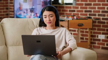 Cheerful woman working remotely while in virtual online videoconference with manager at home in living room. Smiling person talking with coworker on videocall digital meeting on laptop