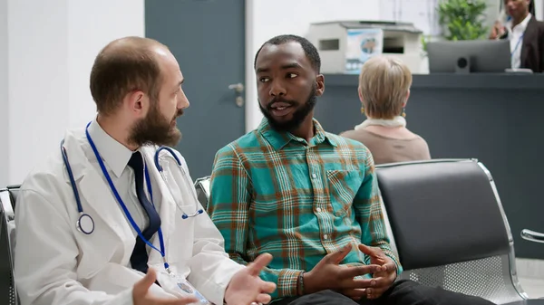 Doctor Talking African American Man Hospital Reception Doing Checkup Examination — Stockfoto