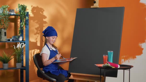 Κοριτσάκι Που Κρατάει Δίσκο Μίξης Ακουαρέλα Για Ζωγραφίσει Καμβά Χρησιμοποιώντας — Αρχείο Βίντεο