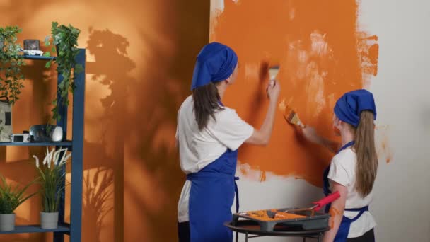 Young People Painting Apartment Walls Orange Color Using Renovating Tools — Stock Video