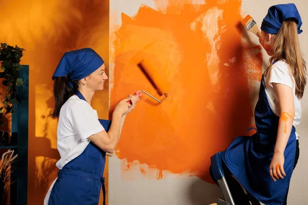 Caucasian Family Using Orange Color Walls Young Child Ladder Painting — Stockfoto