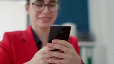 İş kadını mesajlar gönderiyor, akıllı telefondan internete bakıyor, istatistik raporuyla finansal araştırma üzerinde çalışıyor. Başlangıç ofisinde cep telefonu kullanan bir bayan çalışan. Kapat..