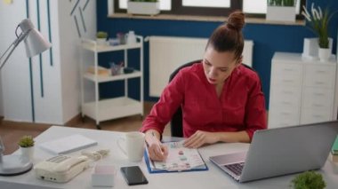 Business woman taking notes on financial papers with charts to plan research project for company development. Job assistant working with sales statistics to obtain management promotion.
