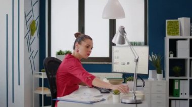 Kadın sekreter, yöneticiden telefon almak için sabit telefonu kullanıyor. Finansal tablolarla iş geliştirme üzerinde çalışıyor. Satış istatistikleri ve araştırmalarıyla ofis çalışanı proje stratejisi planlıyor.