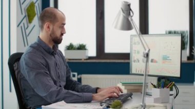 Veri satışı raporuyla çalışan bir iş adamının portresi, şirket geliştirme için finansal strateji planlaması. Başlangıç ofisinde grafik ve grafik istatistikleri kullanan erkek çalışan.
