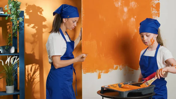 Mother Kid Using Paintbrush Orange Walls Paint Home Interior Doing — Foto de Stock