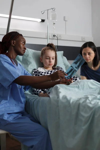 African American Nurse Showing Radiography Scan Image Sick Girl While —  Fotos de Stock