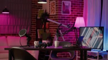 Empty desk equipped for dual vlog with headphones and microphones to broadcast interview on internet. Cozy ambient room with podcast station, for online podcast streaming.