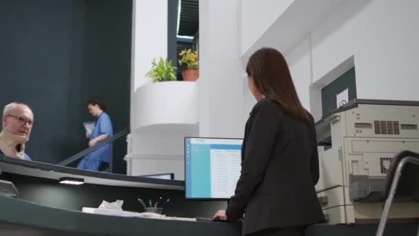 Asian Receptionist Helping Senior Man Cervical Neck Collar Hospital Reception — Vídeo de stock