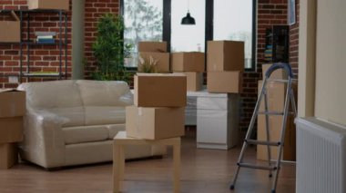 Empty new apartment space with furniture packages in boxes, moving in household property. No people in real estate house to move with things in storage cardboard cargo containers.