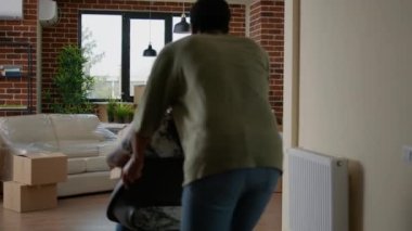 Married couple feeling happy about moving in together in new home, having fun with furniture in rented apartment flat. Homeowners enjoying house relocation after loan investment.