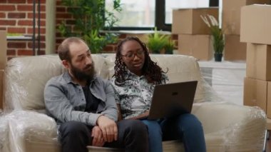 Çeşitli çiftler internet sitesinde ilham ve mobilya arıyor, dizüstü bilgisayardan online alışveriş yapıyorlar. Birlikte ev kredisi alıp daireyi dekore etmek. El kamerasıyla..