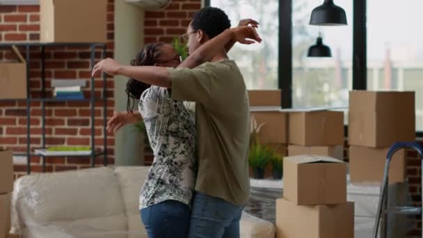 African American Couple Sharing Hug Together Decorating New Rented Apartment — Stockvideo