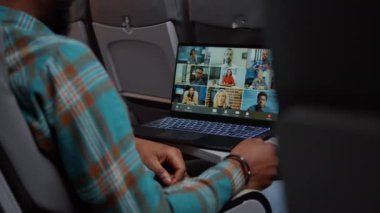 African american passenger talking to business people on videocall teleconference, meeting with colleagues on remote videoconference. Flying with airplane and chatting online. Close up.