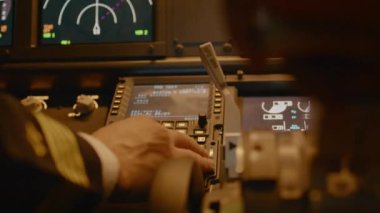 Captain inserting destination coordinates on cabin dashboard, using control panel command to fly airplane. Piloting plane with engine throttle, power switch and radar. Close up. Handheld shot.