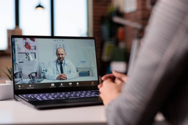 Young woman using videocall telemedicine with doctor, doing healthcare appointment to talk about treatment and telehealth. Meeting in online videoconference with physician to receive medicine.
