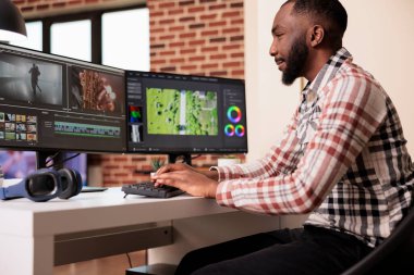 Male digital creator editing video montage on post production software, working on computer. Creating movie content with color grading, edit creative multimedia film footage on app.