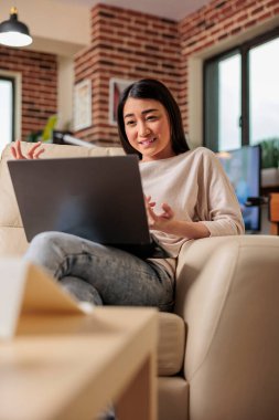 Çevrimiçi internet teknolojisi videosunda gülümseyen güzel Asyalı kadın kameradan feragat ediyor, evde boş zaman geçiriyor dijital web iletişim webcam sohbet beleşçisi evde