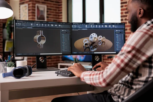 African american technician prototyping machinery product to create gears model for industrial development. Engineer using creative cad software to manufacture graphics invention.