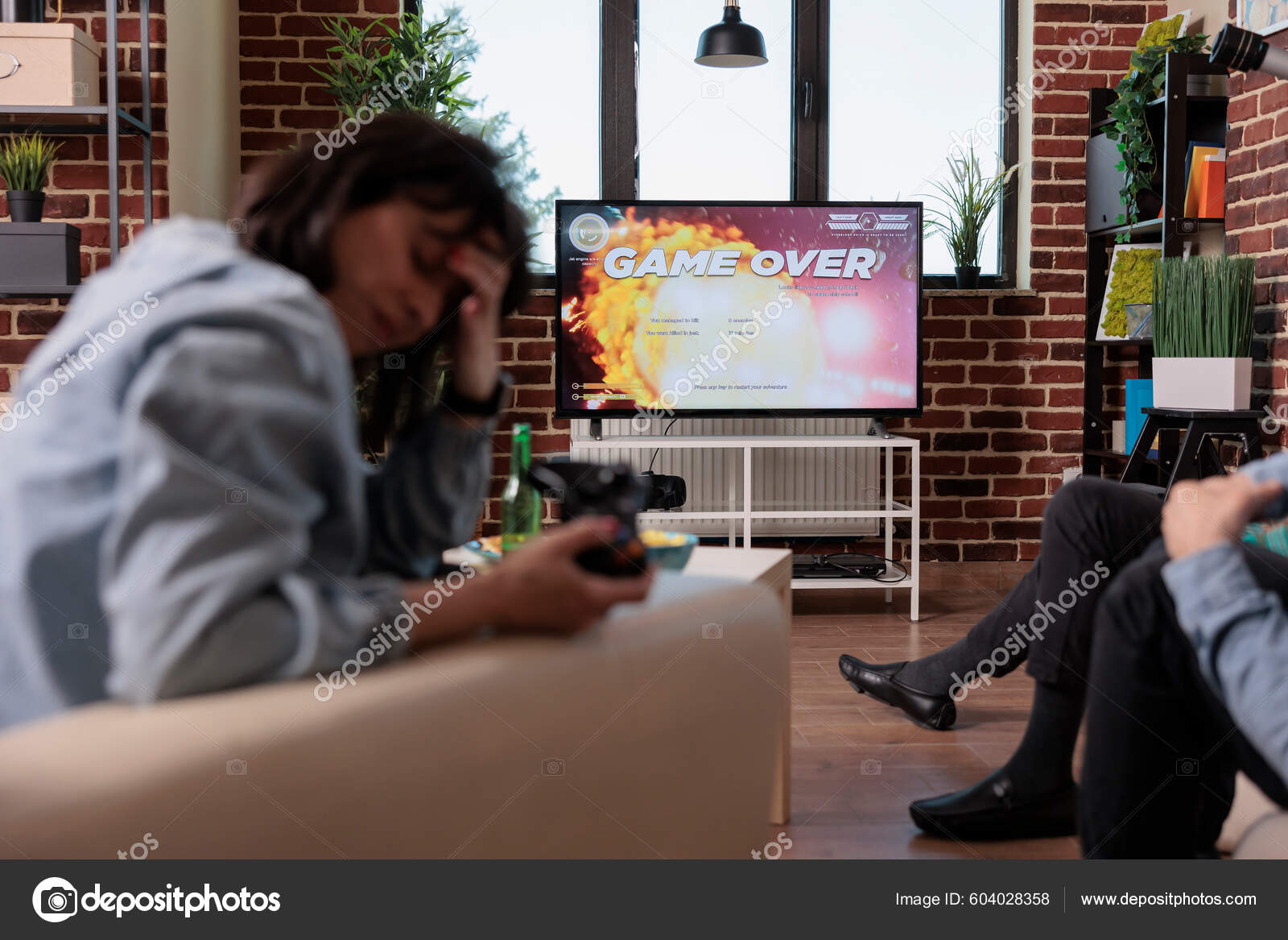 Man disappointed while playing video game with girlfriend at home stock  photo