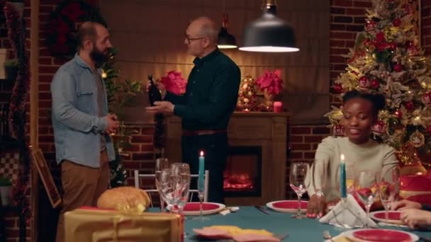 Senior Conversating Young Man Rare Bottle Champagne Brought Christmas Dinner — Stockvideo