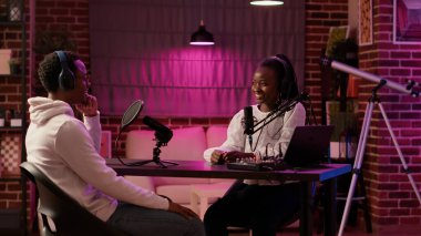 Afrika kökenli Amerikalı kadın içerikli yaratıcı, şarkıcıyla birlikte ev stüdyosunda podcast yapıyor. İnternetteki radyo sunucusu gecenin geç saatlerinde eğlence amaçlı internet şovu için nüfuzlu biriyle röportaj yapıyor..