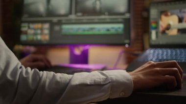 Multimedia artist editing movie footage on post production software, using visual effects on montage for cinematic look. Color correction and grading on video. Handheld shot. Close up.