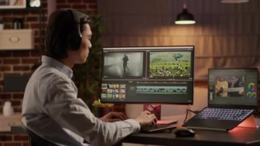 Creative artist editing film montage with visual effects on video editor software, listening to music on headphones. Working with color grading on multimedia app to create movie production.