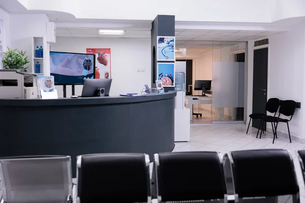 Empty hospital reception desk in lobby and waiting room seats, medical examination appointment with physician. Registration counter with waiting area to help patients with disease diagnosis.