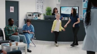 Diverse group of people in busy waiting room lobby with reception desk, using appointment reports to receive medication after medical consultation. Healthcare checkup examination.