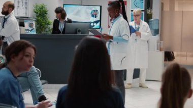 Hastanenin resepsiyon lobisindeki Afrikalı Amerikalı doktorun portresi. Muayene için hasta kabinesine götürme randevusuyla birlikte check up dosyalarını analiz ediyor. Sağlık uzmanlığı olan bir doktor..