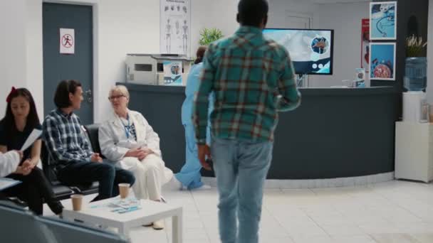 Diverse Patientengruppen Sitzen Wartezimmerbereich Sich Für Einen Termin Anzumelden Und — Stockvideo