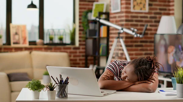 Tired stressed employee falling asleep on desk at remote work, feeling sleepy and overworked at home. Working remotely on business and being exhausted, feeling depressed and unhappy.