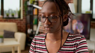 Female freelancer working remotely on laptop from home, using computer and notebook to attend online webinar at do remote work. Browsing internet network to do freelance job at desk.