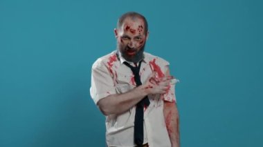 Arka planda korkunç görünümlü bir canavar var. Beyin ölümü gerçekleşmiş yürüyen ölü bir ceset. Kameraya bakıp hırlarken parmağıyla işaret ediyor. Stüdyo çekimi