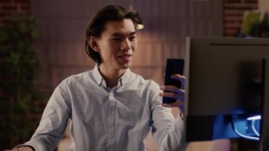 Asyalı iş adamı, telekomünikasyon işi için uzaktan video konferansında akıllı telefonu kullanarak çevrimiçi video görüşmesi yapıyor. Telefon webcam ile sanal tele çalışma konferansı.