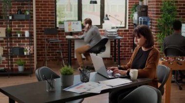Business woman analyzing charts report in startup office, using laptop to plan research presentation. Corporate employee working on project data, sending email and networking.