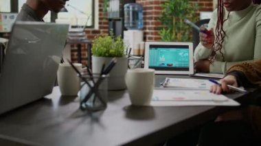 Yönetim kurulu toplantısında fikir üreten çok ırklı bir grup insan, belgelerle ilgili veri tabloları ve istatistik raporlarına bakıyor. Ortaklık işbirliği üzerinde çalışan bir grup iş arkadaşı.