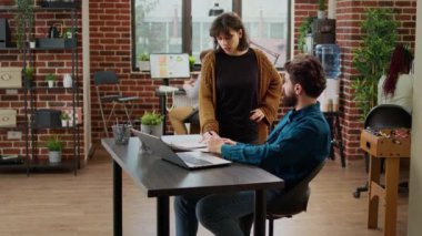 İş adamlarından oluşan bir ekip rapor hazırlamak için e-posta bilgilerini analiz ediyor, doküman ve dizüstü bilgisayardaki verileri kullanıyor. Proje analizi yapmak ve e-posta göndermek için çizelgelerle çalışan erkek ve kadın.